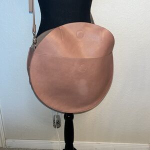 Large Round shoulder bag. Beige pink. Diameter 15 1/2”. Front pocket.